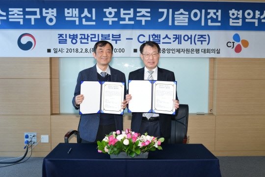 8일 충북 오송 질병관리본부에서 개최한 수족구병백신 기술이전 협약식에서 박도준 국립보건연구원장(왼쪽)과 김병문 CJ헬스케어 R&D사업개발본부 부사장이 기념 촬영을 하고 있다.(질병관리본부 제공)